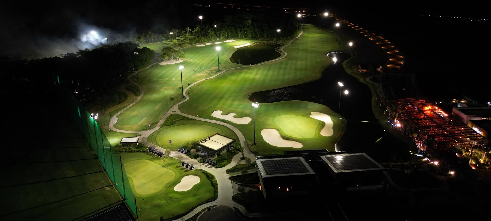 Campo de golfe do All Resort iluminado à noite, visto do alto, em Porto Belo