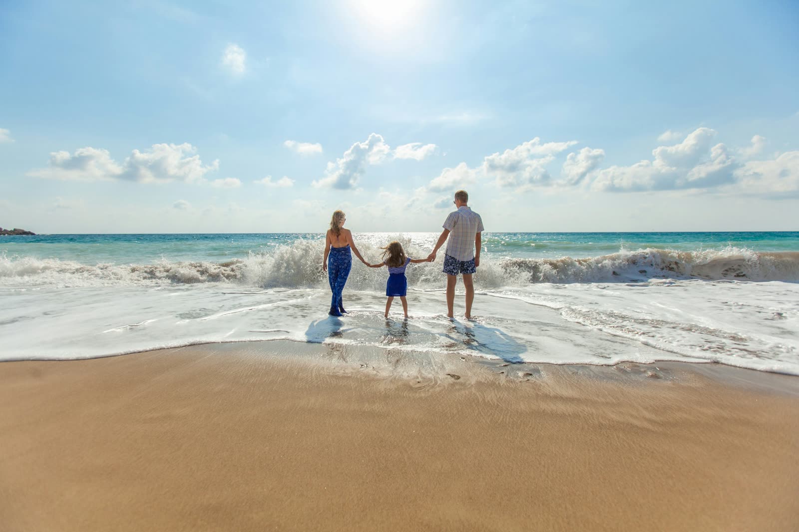 Família de mãos dadas na beira do mar