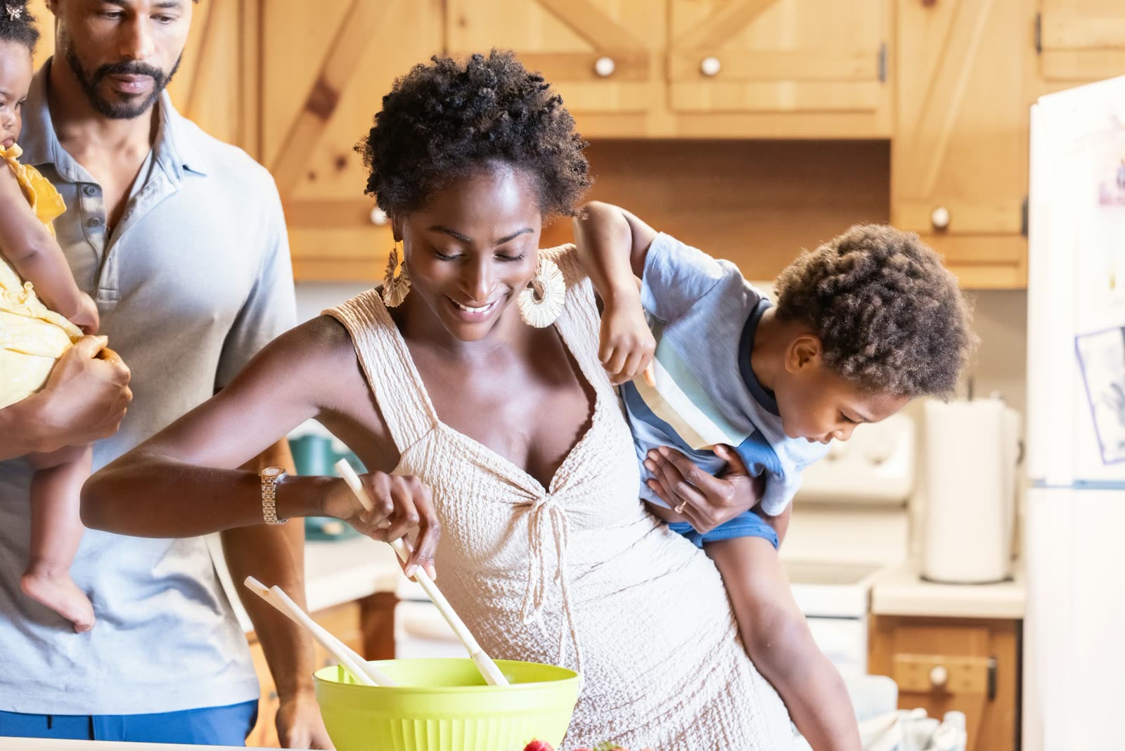 Família cozinhando junta, com uma criança no colo do pai
